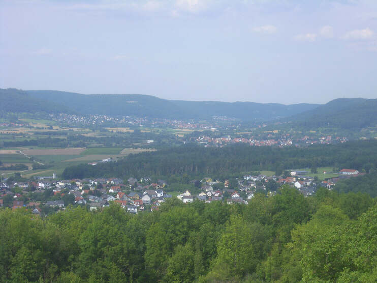 Blick vom Walberlakreuz hinunter zum stlichen Teil von Kirchehrenbach. Dahinter sind Pretzfeld und Ebermannstadt zu erkennen. (Juli 2018)