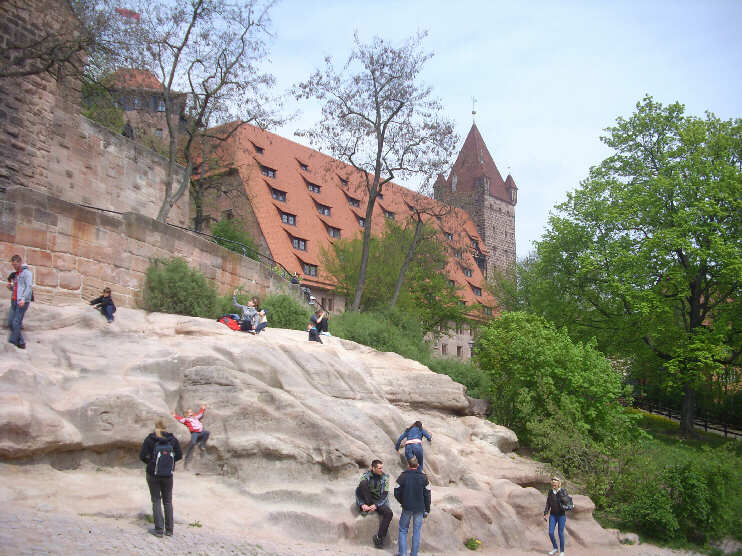 Klettereien auf den Burgfelsen, im Hintergrund die reichsstädtischen Bauten mit dem »Luginsland« (Mai 2013)