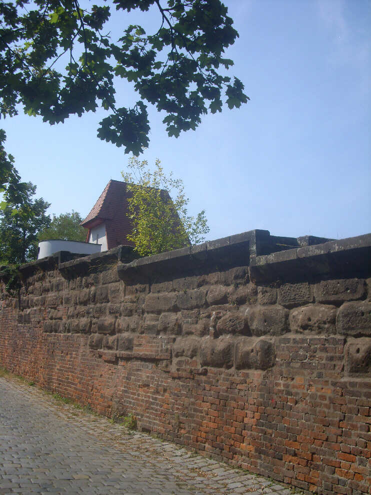 Vestnertormauer mit Blick auf das Dach des Wehrturmes, der im Jahr 2005 wieder errichtet worden ist. Siehe auch unter BURGGRABEN  ZWISCHEN VESTNERTOR & MAXTOR (August 2018)